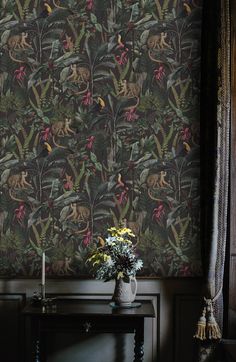 the wallpaper is very colorful and has animals on it, while flowers are in vases