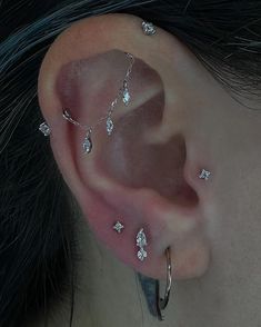 a close up of a person with some piercings on their ear and behind the ear