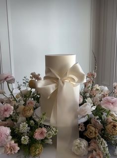 a large white bow on top of a vase filled with flowers