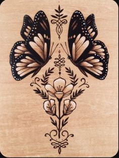 two butterflies are sitting on top of a wooden plaque with floral designs in the middle