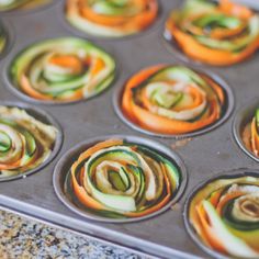 the muffin tins are filled with assorted rolled up cupcakes