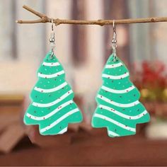 green christmas tree earrings hanging from a branch