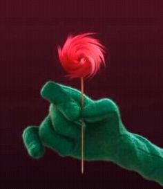 a green hand holding a red flower in it's right hand with the other hand