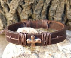 "Beautiful leather Bracelet!!. This simple leather cross bracelet can be given as a gift to that special person in any special occation, Simple and cute handmade 3/8\" leather religious bracelet. Very comfortable & easy to wear. Great gift for anyone on your list or for any special occation! Bracelet Specifications: -3/8\" Brown Leather Band -Red Copper Alloy Cross -Brown Cotton Cord -Adjustable knott To maintain the quality and the beauty of your leather accessory , please DO NOT expose it Adjustable Brown Cross Bracelet, Adjustable Leather Spiritual Bracelet, Brown Cross Bracelet Spiritual Style, Spiritual Brown Cross Bracelet, Leather Wristbands, Simple Leather, Mens Leather Bracelet, Cross Bracelet, Engraved Gifts