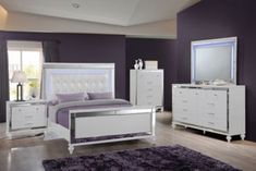 a bedroom with purple walls and white furniture