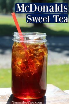 a jar filled with iced tea sitting on top of a wooden table