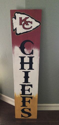 a wooden sign with the word chiefs painted on it in black, red and yellow