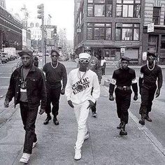 black and white photograph of men walking down the street