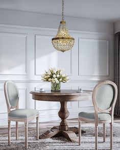 a dining room table with two chairs and a chandelier