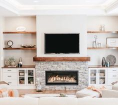 a living room filled with furniture and a flat screen tv mounted above a fire place