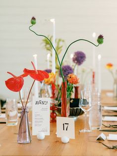 the table is set with flowers, candles and place cards for guests to sit at