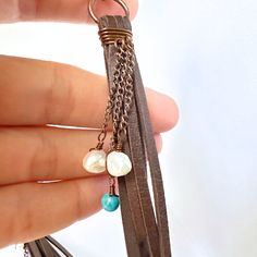 Introducing these stunning handmade leather tassel earrings, carefully wrapped in copper wire on a copper ring for that boho-chic touch. Each earring is beautifully accented with charming turquoise beads, up cycled pearls, and delicate copper chain details. These earrings are a perfect blend of rustic charm and elegant style, making them a unique addition to your jewelry collection. Elevate your look with these one-of-a-kind statement earrings that are sure to turn heads wherever you go. Artisan Brown Jewelry With Tassels, Bohemian Brown Copper Wire Jewelry, Hand Wrapped Brown Dangle Jewelry, Bohemian Hand Wrapped Brown Earrings, Bohemian Brown Hand Wrapped Earrings, Bohemian Brown Hand-wrapped Earrings, Leather Tassel Earrings, Copper Ring, Copper Rings