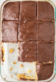 a pan filled with chocolate frosting and pieces of cake sitting on top of each other