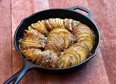 a pan filled with potatoes sitting on top of a wooden table