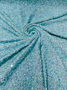 the fabric is blue and green with small glitters on it's surface, as well