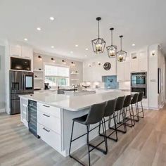 a large kitchen with an island and bar stools