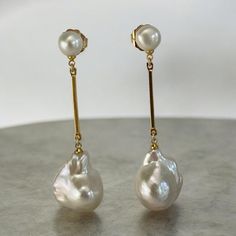 **Handmade Double Pearl Dangling Baroque Earrings** Elevate your elegance with these stunning handmade double pearl dangling baroque earrings. Featuring genuine button pearl studs, approximately 8mm in size, paired with large, lustrous, AAA quality white baroque pearls measuring around 15mm x 21mm. The baroque pearls are suspended from a long, gold-plated bar over a brass body, creating a beautiful, fluid movement with every step. The total length of these earrings from the tip of the pearl stud to the bottom of the baroque pearl is approximately 2.5 to 3 inches. These gorgeous baroque pearl earrings are the perfect accessory for weddings, bridal events, or any formal occasion. Their eye-catching design adds a touch of sophistication to any outfit, ensuring you make a lasting impression. M Handmade Baroque Pearl Earrings For Formal Occasions, Formal Dangle Earrings With Baroque Pearls, Elegant Bridal Dangle Earrings With Baroque Pearls, High Luster Baroque Pearl Earrings For Wedding, Elegant Handmade Teardrop Linear Earrings, Formal Handmade Earrings With Baroque Pearl, Baroque Pearl Long Drop Wedding Jewelry, Luxury Long Drop Pearl Earrings For Wedding, Long Drop Baroque Pearl Earrings For Wedding