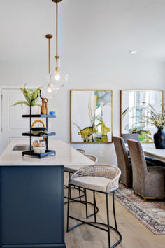 a kitchen with an island and chairs next to it in front of a dining room table