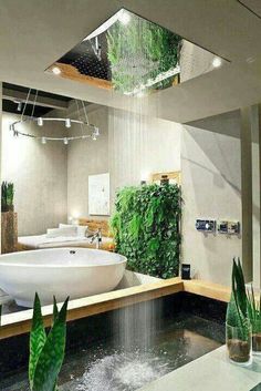 an indoor bathroom with plants growing on the wall and a large bathtub in the middle