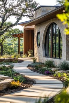 a stone house with arched windows and landscaping