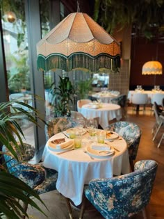 a dining room with blue chairs and white tablecloths