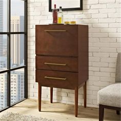 a tall wooden cabinet sitting in front of a window next to a white brick wall