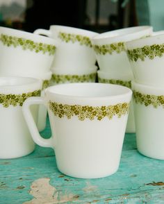 there are many white cups with gold designs on them