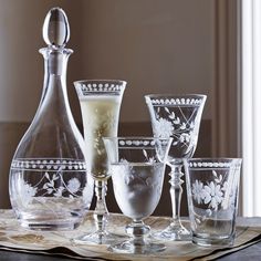 an assortment of wine glasses and decanters on a table