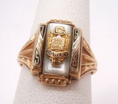 a gold and white ring with an ornate design on the front, sitting on top of a napkin