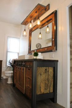 a bathroom with a vanity, mirror and light fixture on the wall over the sink