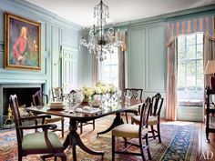 an elegant dining room with blue walls and chandelier