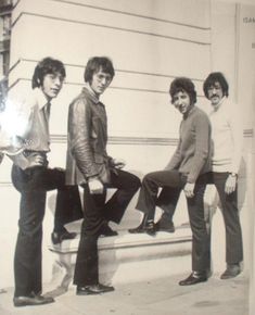 an old black and white photo of four young men posing for a picture on the steps