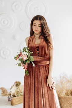 a woman in a brown dress holding a bouquet