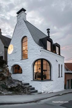 the house is made out of white bricks and has windows that look like they have been built