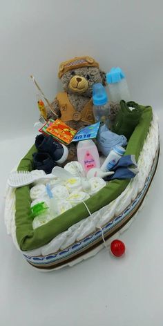 a teddy bear sitting on top of a baby's diaper filled with items