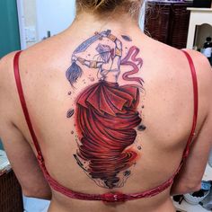 the back of a woman's body with a tattoo on her shoulder and chest