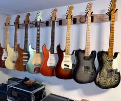 several guitars are hanging on the wall