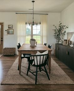 a dining room table with chairs and a rug on the floor in front of it