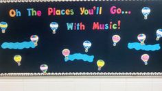 a bulletin board with hot air balloons in the sky and words that read, oh the places you'll go with music