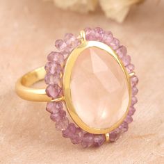 Indian designer Neetu Barathi brings us a superb creation featuring a six-carat rose quartz stone, symbolizing unconditional love. This precious gem is also embellished with little amethyst beads along the bezel for a dapper look. On top of that, the cocktail ring is crafted from 18k gold-plated sterling silver, making a high-quality accessory. Rose Gold Multi-stone Jewelry With Pink Sapphire, Luxury Faceted Gemstones For Anniversary, Rose Gold Multi-stone Pink Sapphire Jewelry, Elegant Round Pink Sapphire Gemstones, Luxury Pink Gemstones For Wedding, Multi-stone Pink Sapphire Jewelry For Gifts, Pink Sapphire Multi-stone Jewelry For Gifts, Elegant Multi-stone Pink Sapphire Jewelry, Luxury Pink Amethyst Gemstone Ring