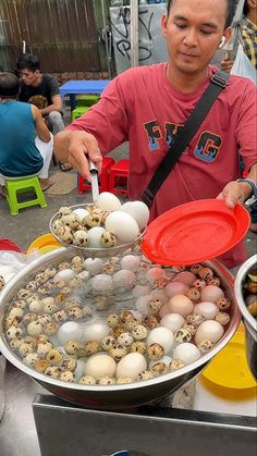 a man standing over a pan filled with eggs