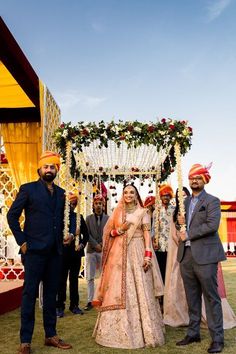 a man and woman standing in front of a wedding arch