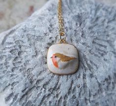 .: Robin ceramic pendant necklace :. LAST ONE ready to ship!   Give a cute gift to someone you love or just adorn yourself with something really unique!  The pendant is made of earthenware clay and glazed with rustic glazes. The pendant have been fired two times, finally at 1940 F (1060 C). Each product is handmade which makes my jewelry unique. Handmade, glazed and fired in my home studio. This pendant is available: ¤ 18" (45cm)  24k gold plated dainty necklace ¤ 18" (45cm) sterling silver necklace I ship all the orders with a registered airmail. Please note that shipping depends on many factors and sometimes might take longer than stated in the shop policies. Shipping to USA, Canada takes about 2-4 weeks Shipping to Australia takes 4-5 weeks Shipping to Europe takes usually 1-2 weeks Ceramic Pendant Necklace, Jewelry Ceramic, Pottery Jewelry, Ceramic Glazes, Robin Bird, Bird Pendant, Bird Necklace, Earthenware Clay, Rustic Jewelry