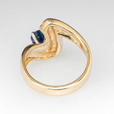 This ribbon freeform ring features an oval cut sapphire, weighing 0.87 carats, in a four-prong setting. One side of the sapphire is accented with seven (7) channel set, round brilliant cut diamonds. The ring measures 15.4mm at the top, rises 6.4mm above the finger, tapering to 3.2mm wide and 1.5mm thick at the base of the shank. It is currently a size 6. The sapphire is lightly abraded but it does not take away from this beauty. Elegant 14k Gold Sapphire Ring With Tension Setting, Elegant Sapphire Ring With Tension Setting For Anniversary, Channel Set Sapphire Ring For Anniversary, Formal Sapphire Ring With Channel Set, Formal Channel Set Round Cut Sapphire Ring, Formal Round Cut Channel Set Sapphire Ring, Elegant Oval Topaz Ring With Tension Setting, Anniversary Sapphire Ring With Channel Set, Elegant Sapphire Ring With Channel Set For Formal Occasions