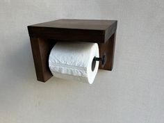 a wooden toilet paper holder mounted on the wall