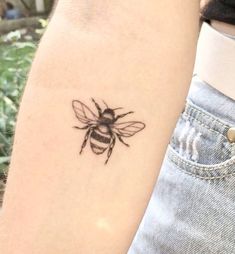 a small bee tattoo on the left arm