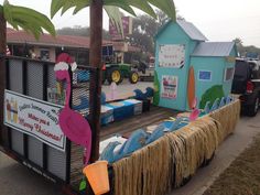 a float made to look like a beach hut with palm trees on the sides and an umbrella