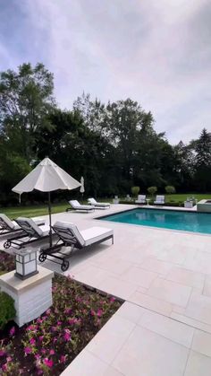 a pool with lounge chairs and an umbrella next to it