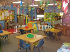 a classroom filled with lots of desks covered in colorful paper streamers and decorations