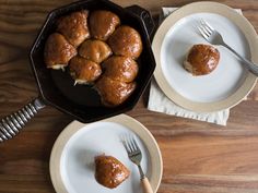 two white plates topped with pastries next to a skillet filled with one piece of bread